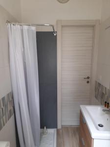 un bagno con tenda da doccia e lavandino di Villetta mare di Sicilia a Fontane Bianche