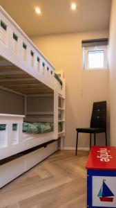 a room with two bunk beds and a chair at Strandhuis aan zee in Noordwijk