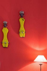 a red wall with two yellow decorations on a wall at Zenana Boutique Hotel in San Candido