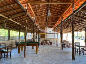 a room with a ping pong table and chairs at Chalé Temporada Porto dos Lençóis - Lençóis Maranhenses in Barreirinhas