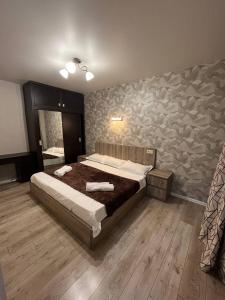 Un dormitorio con una cama y una pared de piedra. en AnNi old Tbilisi apartaments, en Tiflis