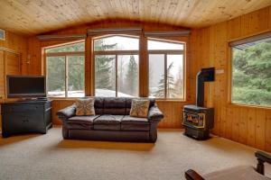 sala de estar con sofá de cuero y fogones en Ronald Vacation Rental Cabin with Private Hot Tub! en Ronald