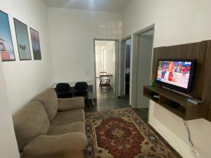uma sala de estar com um sofá e uma televisão de ecrã plano em Casa 2 dorm, otima localizacao, Wi-Fi, Gar, pet em Campinas