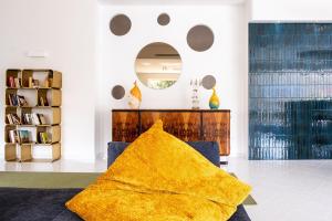 OLIVETO A MARE - Suite & Apartment في أسشيا: بطانية صفراء جالسة على أريكة في غرفة المعيشة