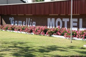 a sign on the side of a building with flowers on it at Camellia Motel in Narrandera