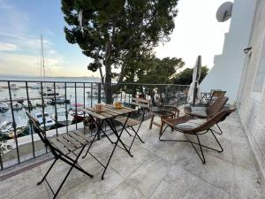 een balkon met een tafel en stoelen en uitzicht op een jachthaven bij V&T Apartment in Brela