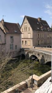a bridge over a river in a city with buildings at Charmant Duplex - Au bord de l'Eure in Chartres