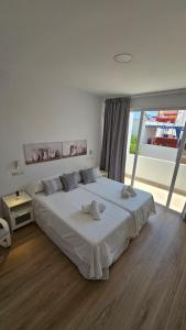 a bedroom with a large bed and a large window at Apartamento Trajano in Santiponce