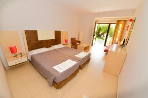 a bedroom with a large bed and a table and chairs at Medusa Lux Apartments in Liapades