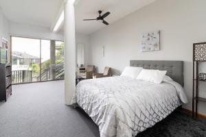 a white bedroom with a bed and a balcony at Bright Spacious Studio High Ceilings Emerald Hills in Emerald Lake Hills