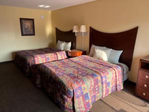 Postel nebo postele na pokoji v ubytování All Star Inn & Suites