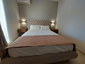 a bedroom with a large bed with two lamps at K & A Studios 1 in Nydri