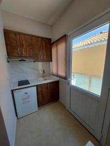 a small kitchen with a sink and a window at K & A Studios 1 in Nydri