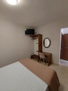 a bedroom with a bed and a desk and a mirror at K & A Studios 1 in Nydri