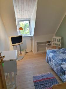 1 dormitorio con cama, escritorio y ventana en Pegasus Bed & Breakfast, en Hillerød