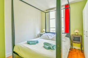 ein Schlafzimmer mit einem Himmelbett und Handtüchern darauf in der Unterkunft Bright Parisian Flat - Marais in Paris