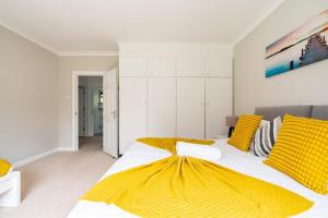 a bedroom with a large bed with yellow pillows at Spacious Home- Great transport links and location- Families- contractors- professionals in Watford