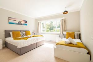 1 dormitorio con 2 camas y ventana en Spacious Home- Great transport links and location- Families- contractors- professionals, en Watford