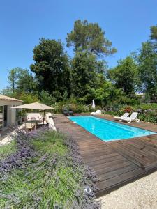 uma piscina com um deque de madeira ao lado de uma casa em Villa OHA close Cannes,Nice, Valbonne , Opio em Roquefort Les Pins