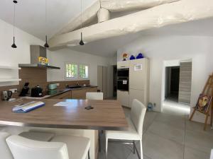 uma cozinha com uma mesa de madeira e cadeiras brancas em Villa OHA close Cannes,Nice, Valbonne , Opio em Roquefort Les Pins