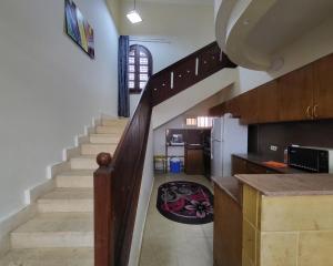 a hallway with a staircase and a kitchen with a rug at Lake & Sea View Duplex in Marina 2 in El Alamein