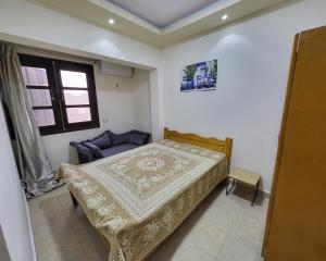 a small bedroom with a bed and a window at Lake & Sea View Duplex in Marina 2 in El Alamein
