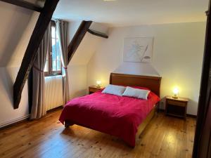- une chambre avec un lit doté d'une couverture rouge et d'une fenêtre dans l'établissement Le Domaine des Tostes, à Bonneville-la-Louvet