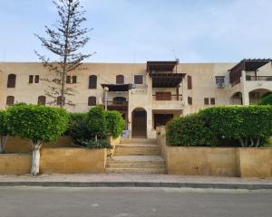 a building with a staircase in front of it at Lake & Sea View Duplex in Marina 2 in El Alamein