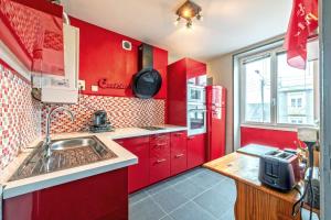 - une cuisine rouge avec évier et réfrigérateur rouge dans l'établissement kerbonne furnished flat, à Brest