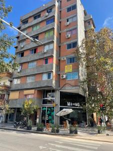 a tall building on a city street with a building at The Top Apartment, desayuno de bienvenida in San Miguel de Tucumán