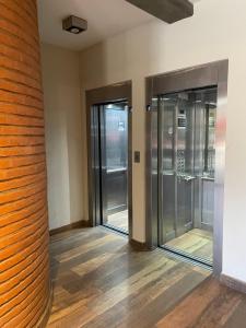 two glass doors in a room with wooden floors at The Top Apartment, desayuno de bienvenida in San Miguel de Tucumán