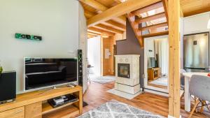sala de estar con TV y chimenea en Leśna Oaza, en Ostróda
