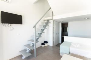a white apartment with a spiral staircase in a room at Lectus Mykonos in Paraga