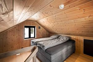 a bedroom with a bed in a wooden cabin at Tonningssætra Mountain Lodge in Stryn