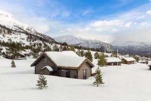 a small house in the snow with mountains in the background at Tonningssætra Mountain Lodge in Stryn
