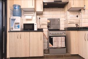 cocina con armarios de madera y horno con fogones en Luxurious-2 bedroom Furnished Apartment, en Nairobi