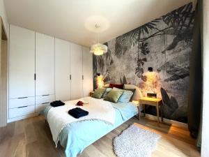 - une chambre avec un grand lit orné d'une peinture murale dans l'établissement WYSZYŃSKIEGO Apartment - Self Check-In 20h - Parking &Lift, à Wrocław