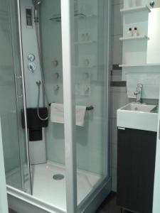 una ducha con una puerta de cristal junto a un lavabo en BruStar Sagrada Familia, en Barcelona