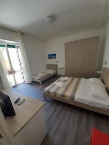 a bedroom with a large bed and a tv in it at La Llua Alghero in Alghero