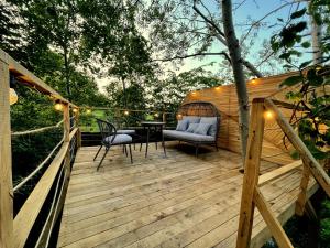 a wooden deck with a chair and a table at Przystanek Czasu - domek kopułowy in Sułów