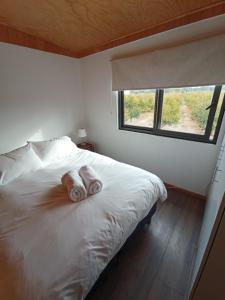 1 dormitorio con 1 cama con 2 toallas en CASA PEQUEN, en Santa Cruz