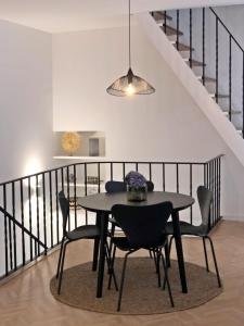 a dining room with a table and chairs and a staircase at Charme do Largo - Apartamento in Lagoa
