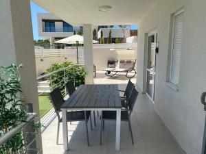 a table and chairs on the balcony of a house at EllaVis Apartments in Vis