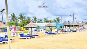 a beach with chairs and umbrellas on a beach at Hotel Petit Brussel in Lomé