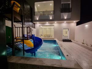 a indoor swimming pool with a slide in a house at فلل شدا ورقان بالهدا in Al Hada