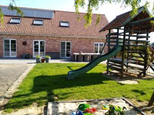 a playground with a slide in a yard at 't Hooghe Licht Bed & Breakfast in Zonnebeke