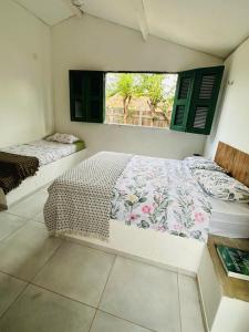 um quarto com 2 camas e uma janela em Pousada Vila Matury em Icapuí