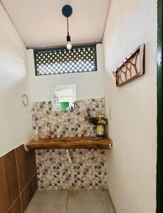 a bathroom with a window and a tile wall at Pousada Vila Matury in Icapuí