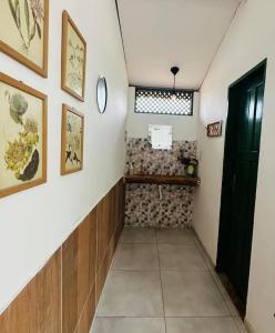 a hallway in a house with paintings on the wall at Pousada Vila Matury in Icapuí