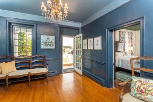 a blue bedroom with a bed and a chandelier at By the Side of the Road Inn & Cottages in Harrisonburg